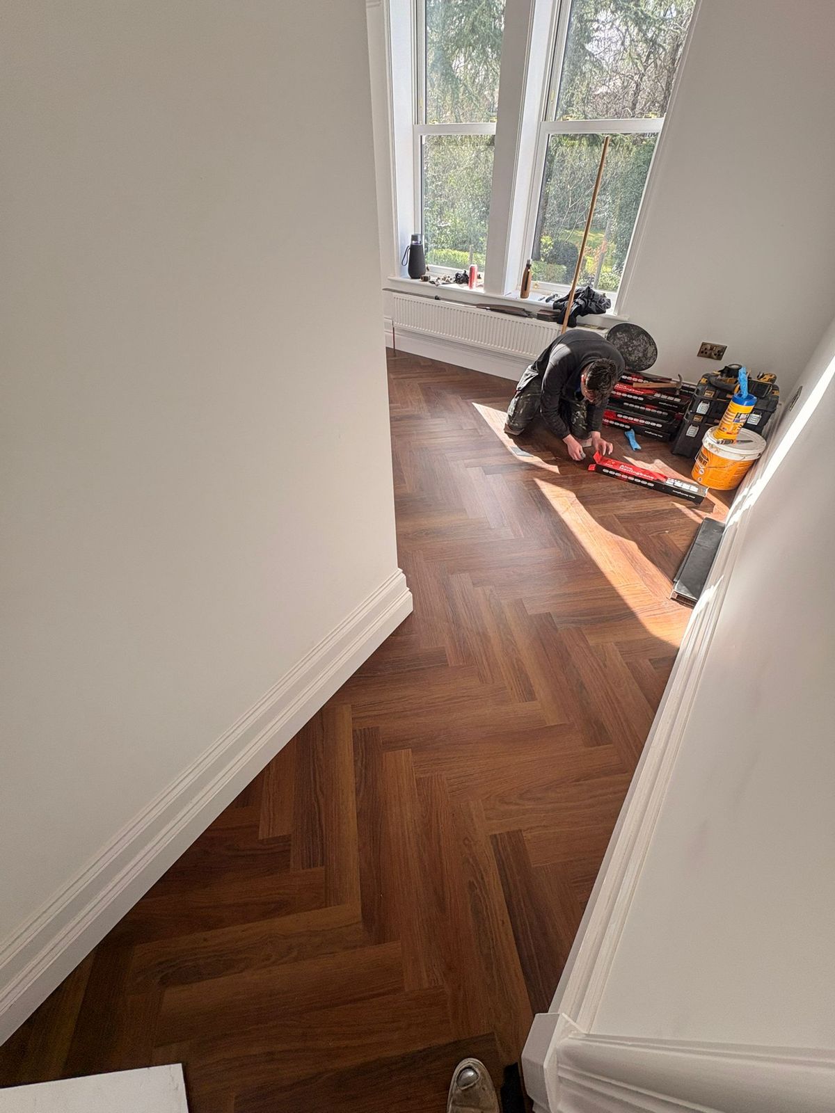 Fitter laying herringbone LVT in a Warrington home